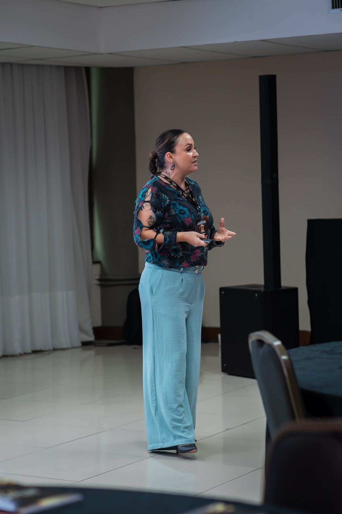 Cynthia M. Cominesi palestrando em um salão de eventos.